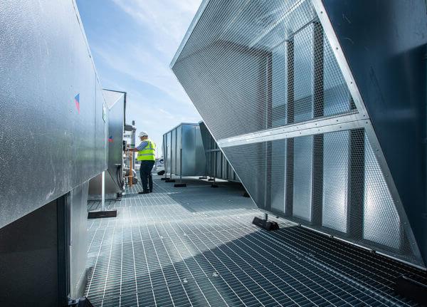 Mitie engineer servicing heat pumps and air conditioning units on a roof